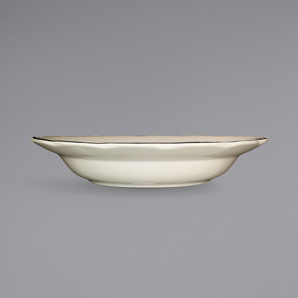 A white stoneware pasta bowl with a black rim.