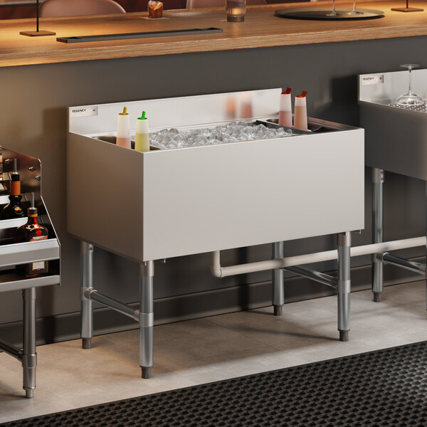 A stainless steel underbar ice bin with a cold plate and bottle holders, designed for commercial bar use.