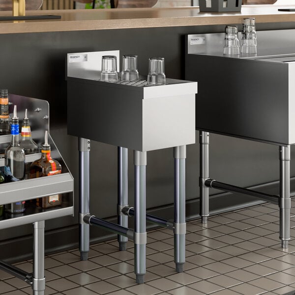 A stainless steel underbar drainboard with glasses placed upside down on top.