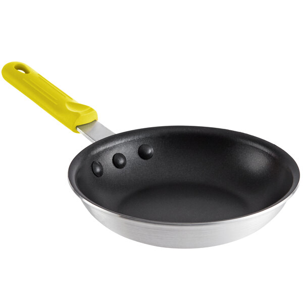 A black frying pan with a yellow silicone handle.