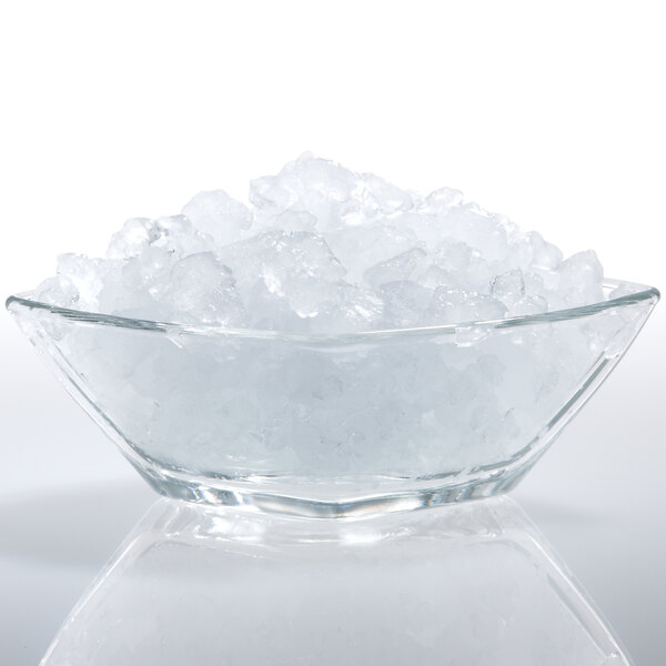 A clear glass of flake ice on a white background.
