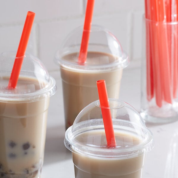 A group of plastic cups with red pointed straws.