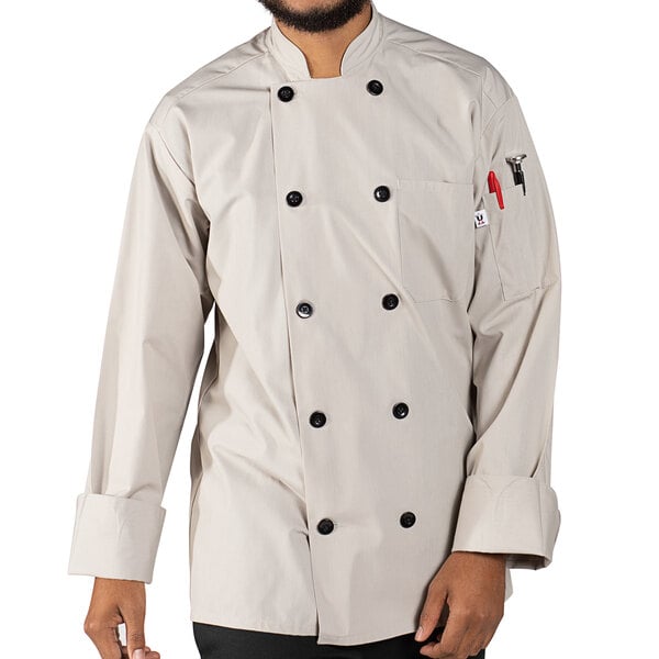 A person wearing a white Uncommon Chef long sleeve chef coat with 10 buttons.