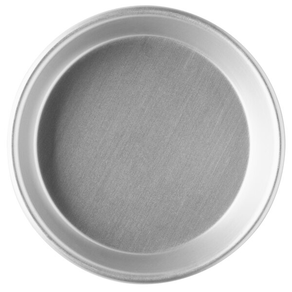 A close-up of a round silver Vollrath tapered deep dish pizza pan.