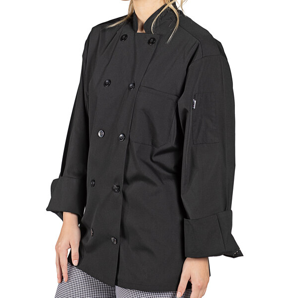 A woman wearing a black Uncommon Chef long sleeve chef coat.