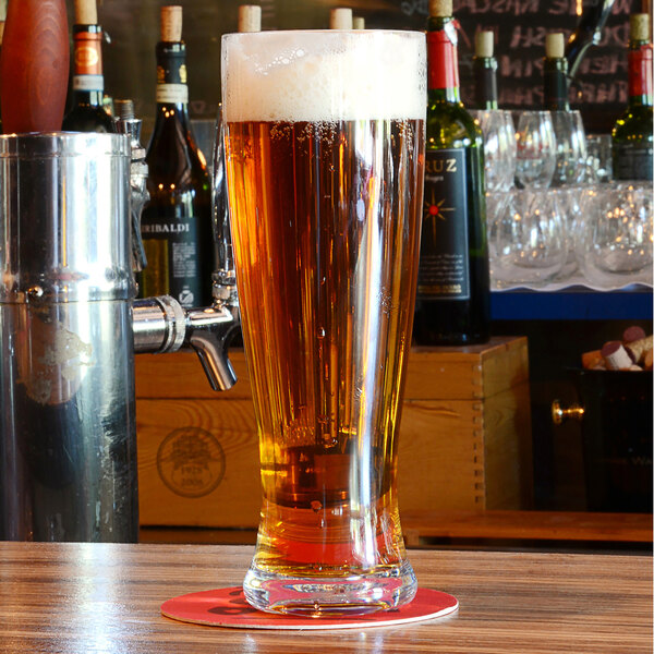 A Front of the House Drinkwise Tritan plastic Pilsner glass of beer on a table.