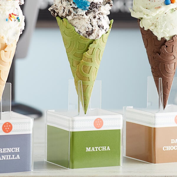 A Konery matcha waffle cone stand holding three waffle cones of ice cream.