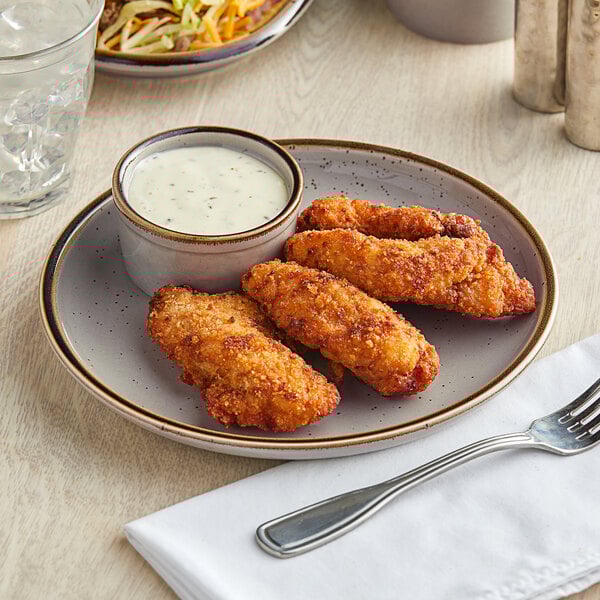An Acopa Keystone granite gray stoneware coupe plate with fried chicken strips and sauce on a table with a fork.