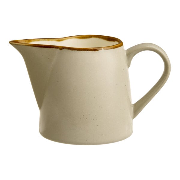 A granite gray stoneware creamer with a handle and a brown-rimmed spout.