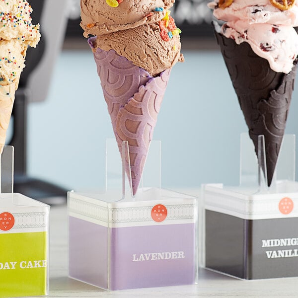 A Konery lavender waffle cone stand holding three ice cream cones on a counter.