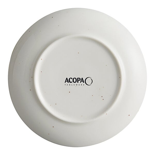 An Acopa Keystone stoneware coupe plate in white with black specks.