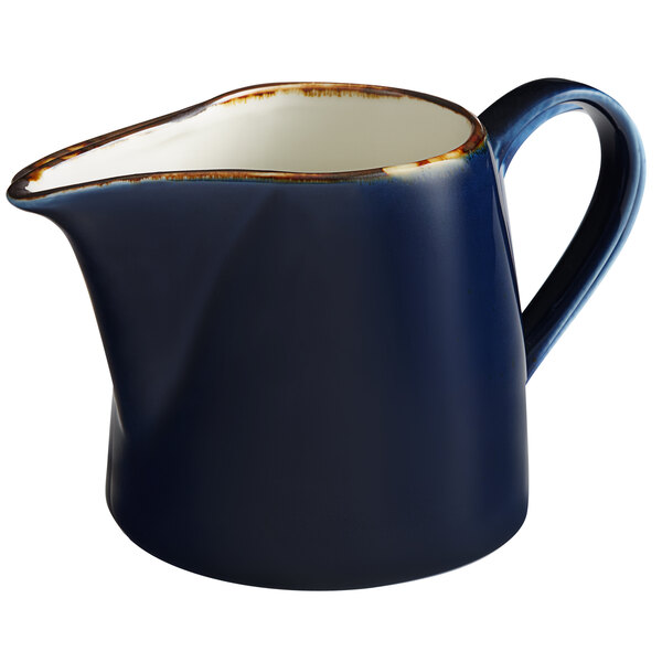 An Acopa Keystone Azora Blue stoneware creamer with a blue and white design.