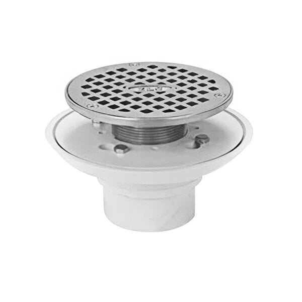 A Zurn white PVC shower drain with a round metal strainer over the drain hole.