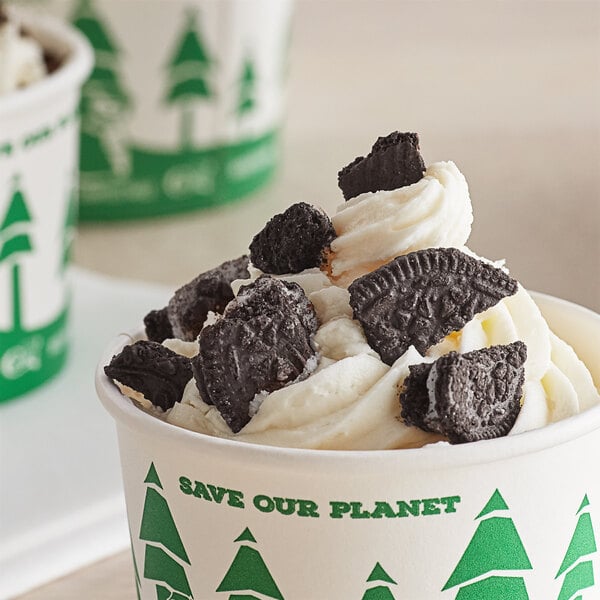 A cup of ice cream with chocolate chip cookies on a counter.