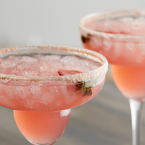 Two pink drinks with salt on the rim.