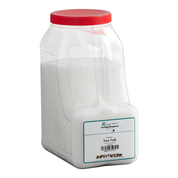A large plastic container of Regal coarse sea salt with a red lid.