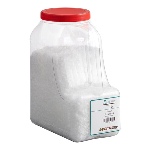 A large plastic container with a red lid filled with natural sea salt flakes.