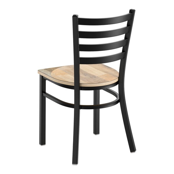 A black metal ladder back chair with a detached driftwood-colored wooden seat.