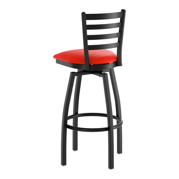 A black metal ladder back swivel bar stool with a red vinyl padded seat.