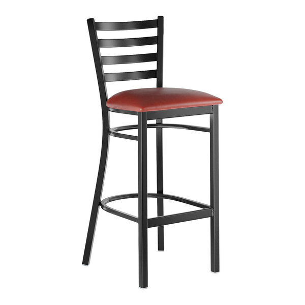 A black metal bar stool with a ladder back design and a burgundy vinyl padded seat.