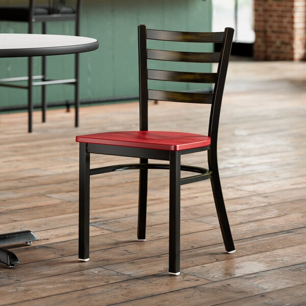 A Lancaster Table & Seating distressed copper ladder back chair with a mahogany seat on a wooden floor.