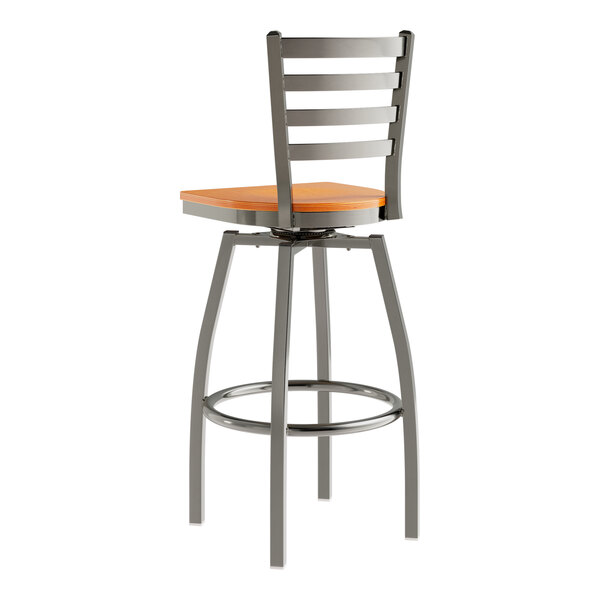 A Lancaster Table & Seating metal ladder back bar stool with a cherry wood seat.