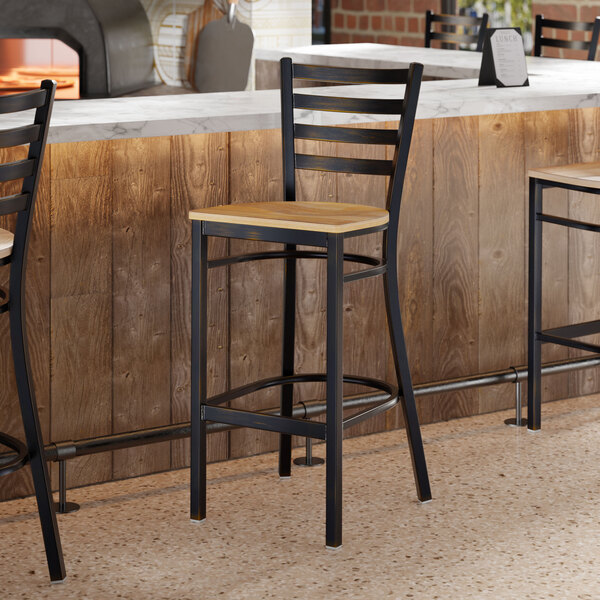 A bar stool with a distressed copper finish ladder back and a driftwood seat.