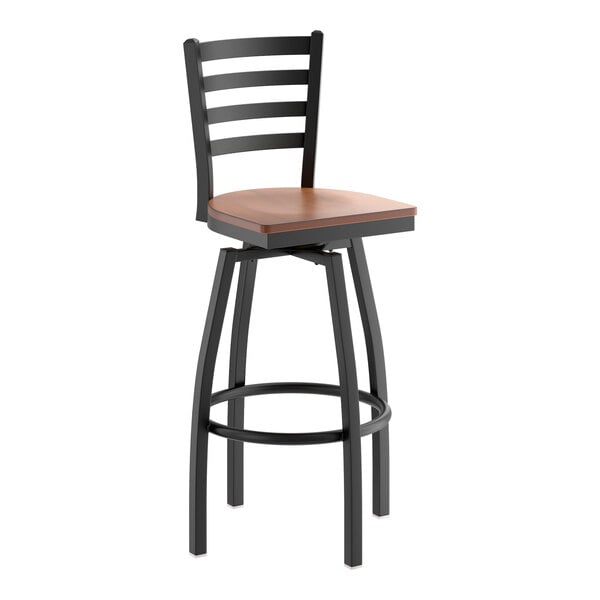 A black metal bar stool with a ladder back design and an antique walnut wood seat.