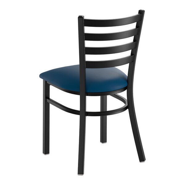 A black ladder back chair with a navy blue vinyl padded seat.