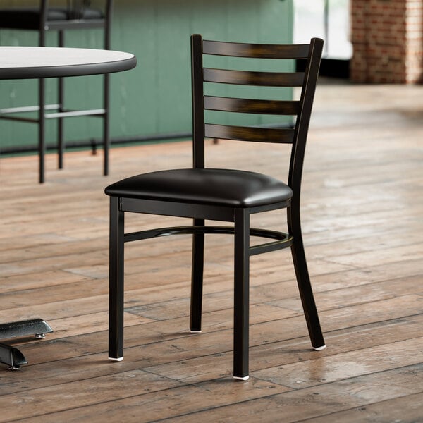 A Lancaster Table & Seating black chair with black cushion detached.