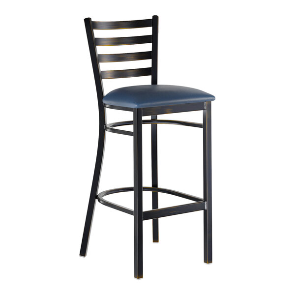 A metal bar stool with a distressed copper finish, ladder back design, and a navy blue vinyl padded seat.