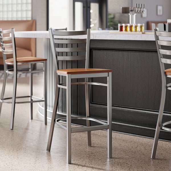 A group of Lancaster Table & Seating ladder back bar stools with antique walnut seats.