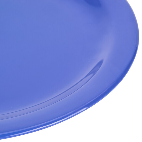 A close-up of a blue Carlisle Dallas Ware melamine plate with a curved edge.