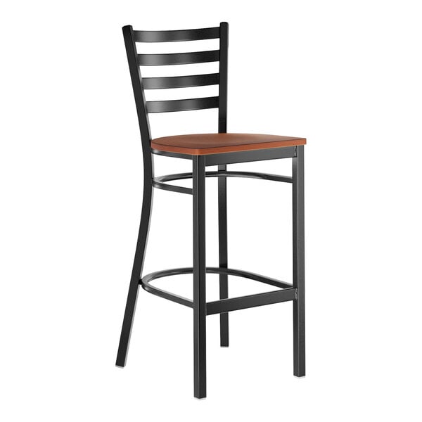 A black metal ladder back bar stool with an antique walnut wood seat.