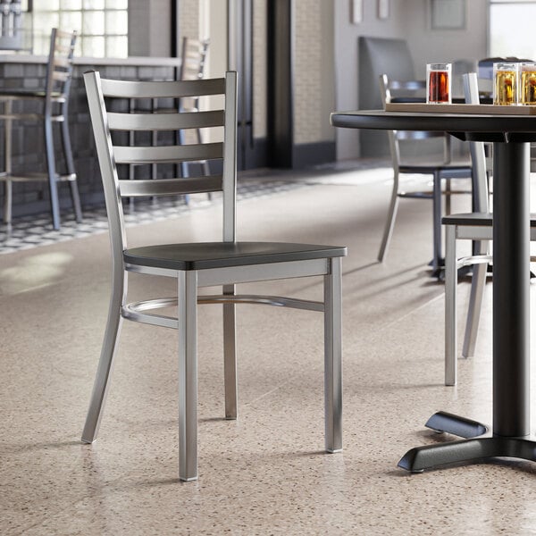 A Lancaster Table & Seating ladder back chair with a detached black wood seat.