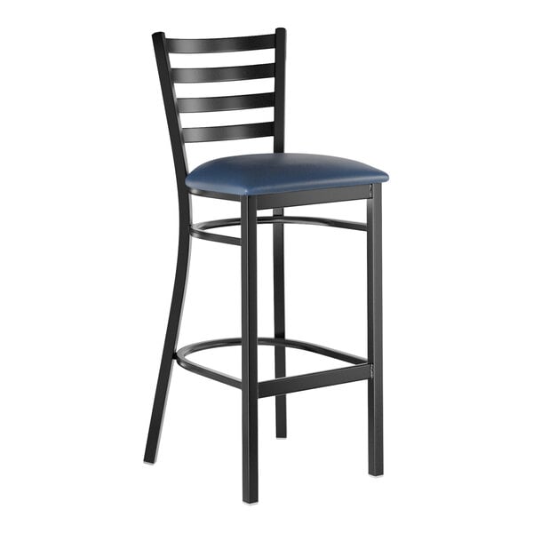 A black metal bar stool with a ladder back design and a navy blue vinyl padded seat.