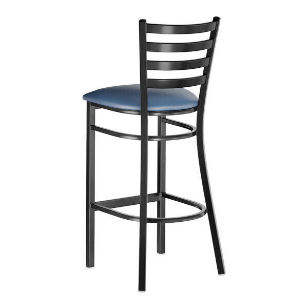 A black metal bar stool with a ladder back design and a navy blue vinyl padded seat.