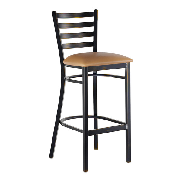 A metal bar stool with a ladder back design and a light brown vinyl padded seat.