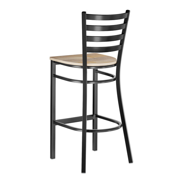 A black metal ladder back bar stool with a light wood seat.