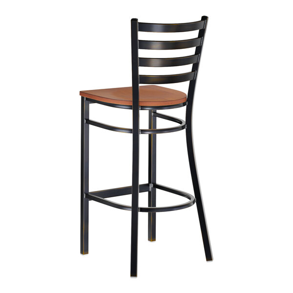 A metal ladder back bar stool with a distressed copper finish and an antique walnut wood seat.