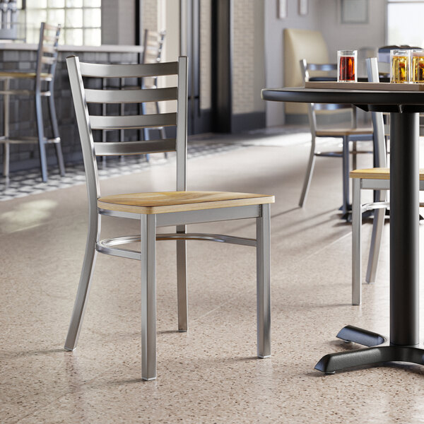 A Lancaster Table & Seating clear coat finish ladder back chair with a driftwood seat at a table with drinks.