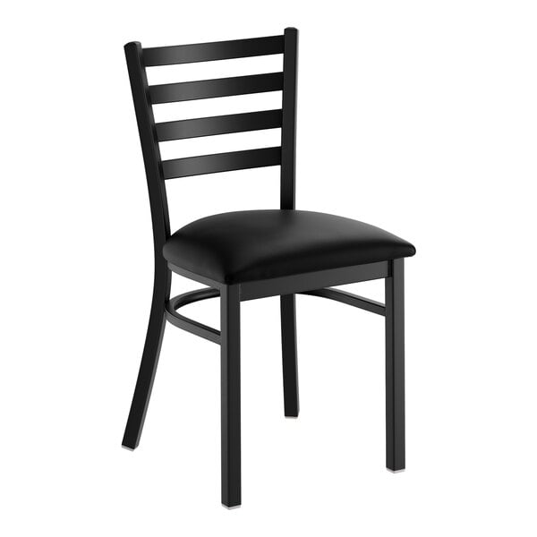 A black ladder back chair with a padded black vinyl seat.