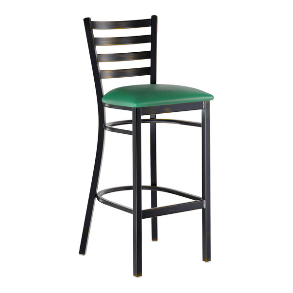 A metal bar stool with a distressed copper finish, ladder back design, and a green vinyl padded seat.