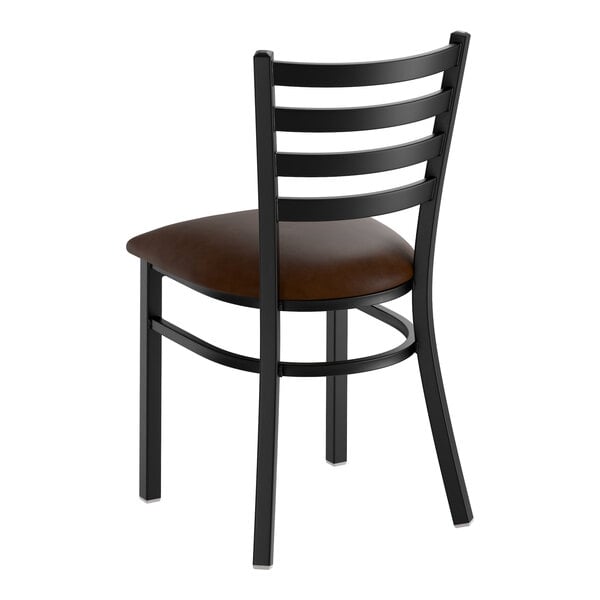 A black metal ladder back chair with a dark brown vinyl padded seat.
