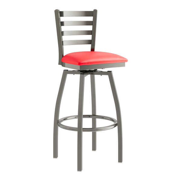 A Lancaster Table & Seating clear coat finish metal swivel bar stool with a red vinyl cushion.
