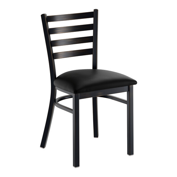 A black metal ladder back chair with a padded black vinyl seat.