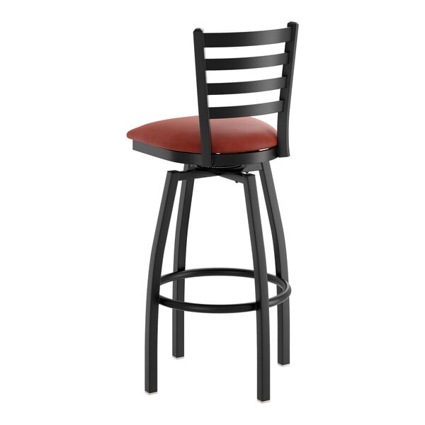 A black metal ladder back swivel bar stool with a burgundy vinyl padded seat.
