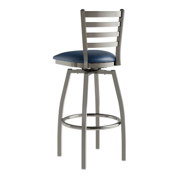 A Lancaster Table & Seating metal swivel bar stool with a navy vinyl padded seat.