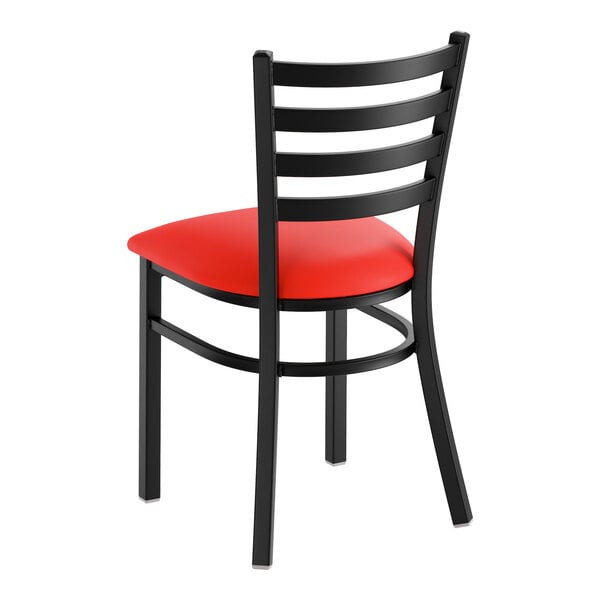 A black ladder back chair with a red vinyl padded seat.