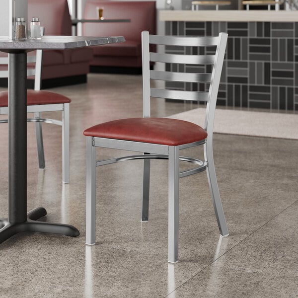 A Lancaster Table & Seating metal restaurant chair with a burgundy vinyl padded seat.